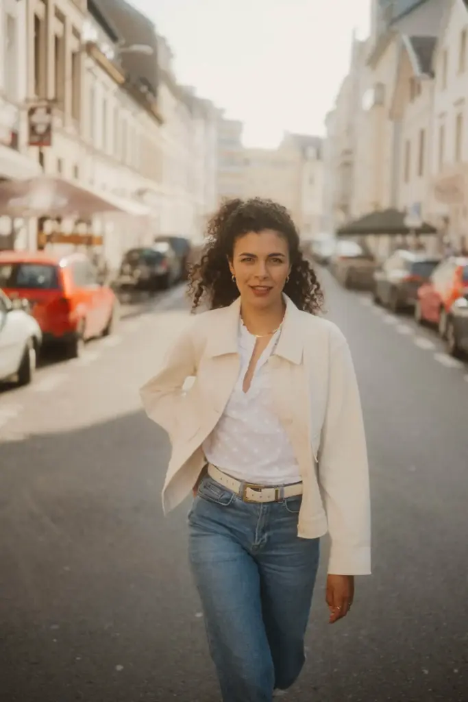 Frau geht durch eine helle Straße, der Hintergrund bleibt weich und unaufdringlich