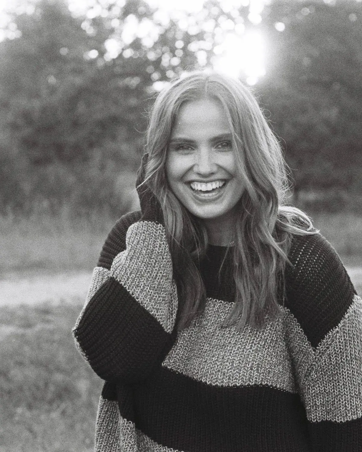 Körniges Schwarzweiß mit lachender Frau und spürbarer Bewegung im Moment