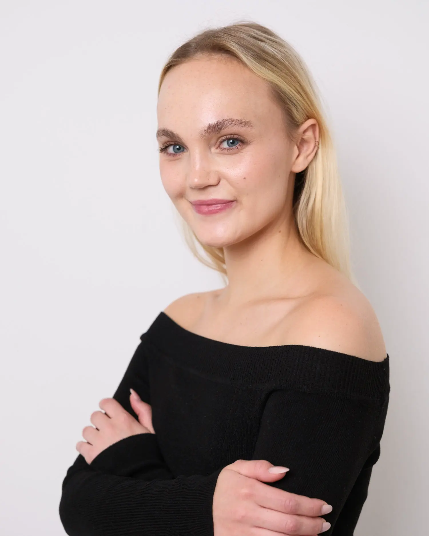 Model im reduzierten Studio-Setup mit direktem Blick und ruhiger Haltung