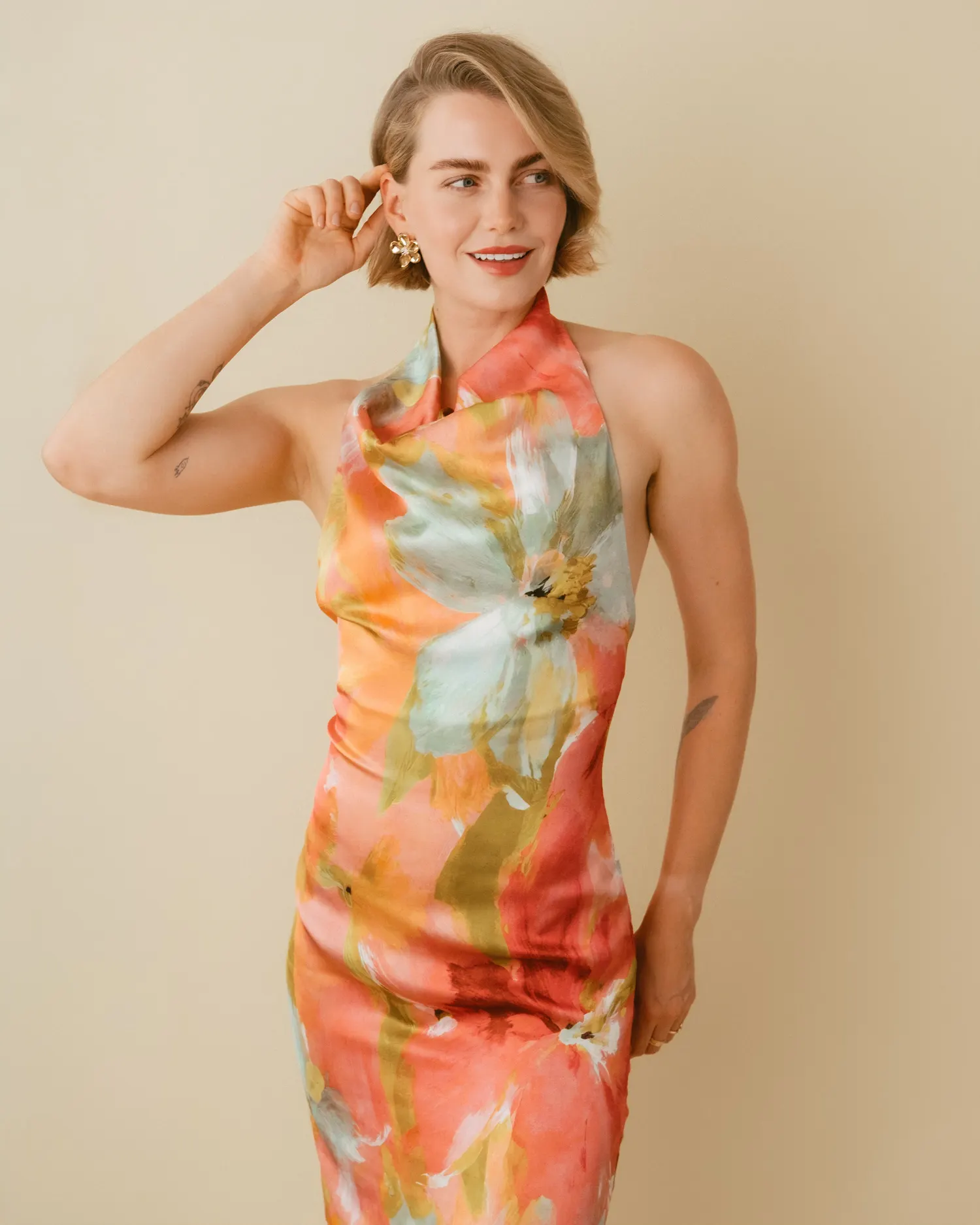 Model in farbigem Kleid vor warmem Studiohintergrund