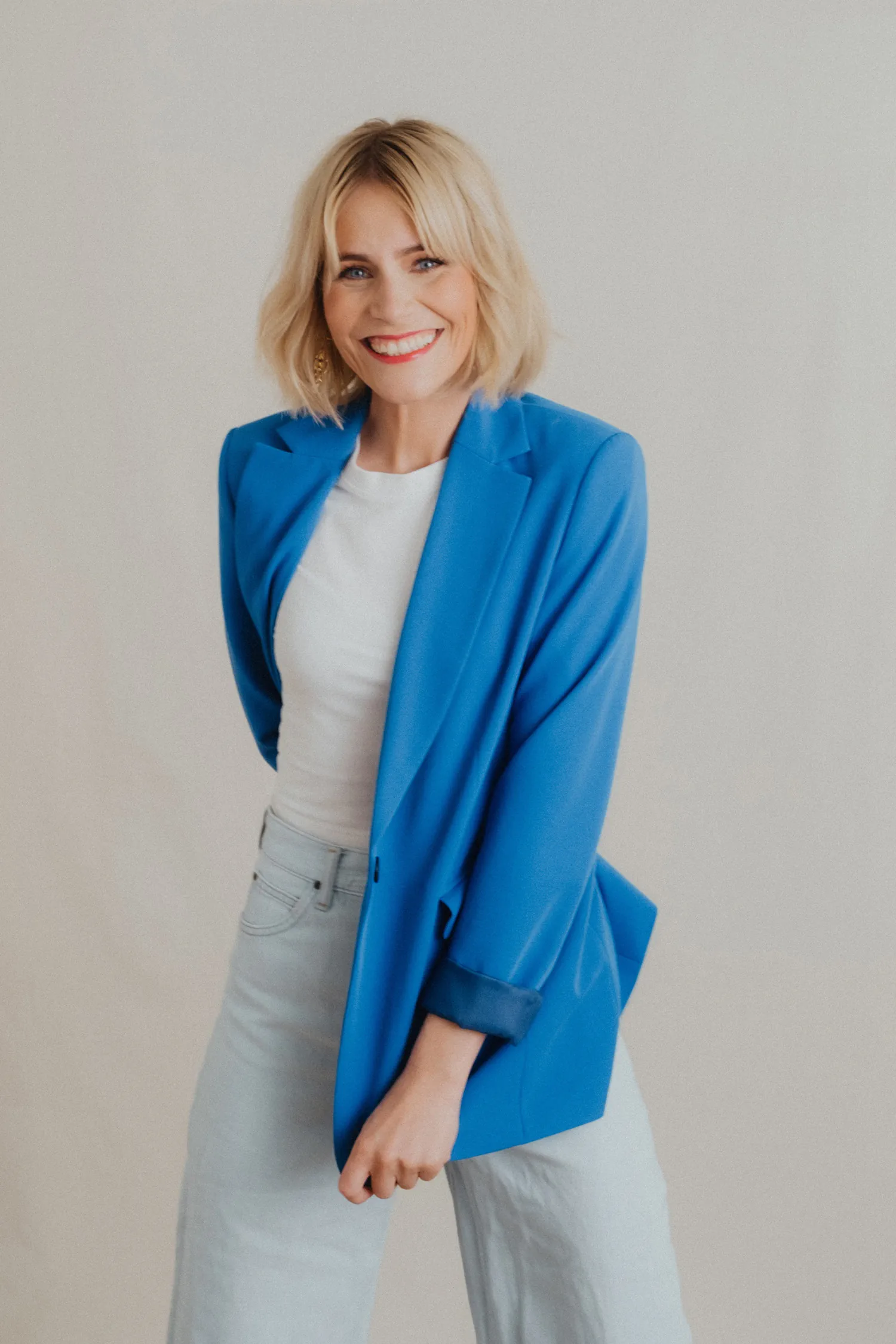 Julia Kleine im blauen Blazer über weißem Shirt, lächelnd in die Kamera